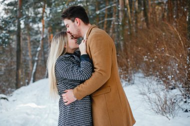 karlı bir günde parkta yürüyen mutlu genç çift