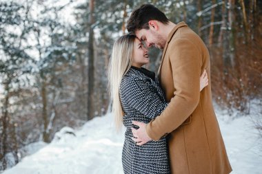 karlı bir günde parkta yürüyen mutlu genç çift