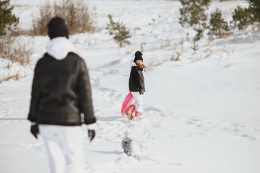 Family on family Christmas vacation. Woman and little girl in a forest. People walks.