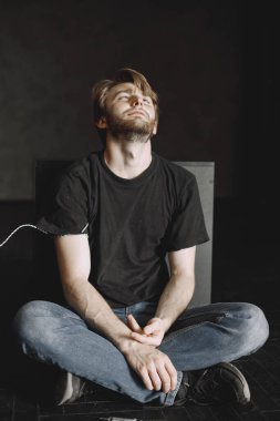 Kötü alışkanlıklar sorunu. Uyuşturucu bağımlısı adam dozda almış. Yapayalnız oturuyor..