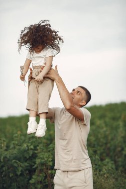 Yaz parkında bir aile. Beyaz tişörtlü baba. Sevimli küçük kız.