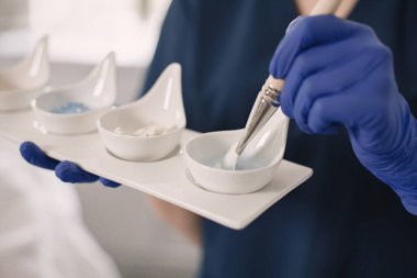 Dört farklı kozmetik krem kavanozunu kapat. Kozmetik uzmanı cilde sürmeden önce nemlendirici krem losyonları ve diğer maskeleri tutuyor. Kendini tedavi etme kavramı.