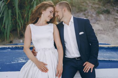 Sahilde genç kocasıyla beyaz elbiseli genç güzel uzun saçlı gelin