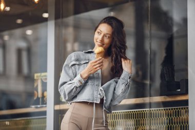 Woman in a summer city. Lady with ice cream. Brunette by the building.