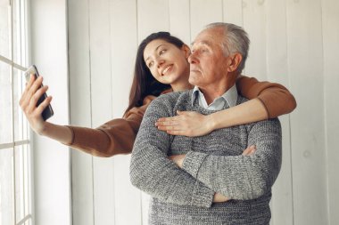 Büyükbabam evde. Torunu olan yaşlı bir adam. Gri kazaklı son sınıf öğrencisi. Cep telefonlu aile.