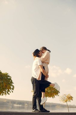 Deniz kenarında bir çift. Siyah şapkalı adam. Günbatımı arka planında eşleşin.