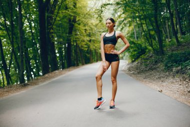 Bir yaz parkta eğitim hoş bir bayan. Yoga yaparken esmer. Siyah top bir kız