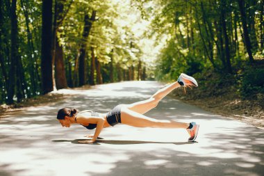 Bir yaz parkta eğitim hoş bir bayan. Yoga yaparken esmer. Siyah top bir kız