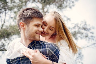 Parktaki sevimli çift. Beyaz elbiseli kadın. Mavi gömlekli adam.