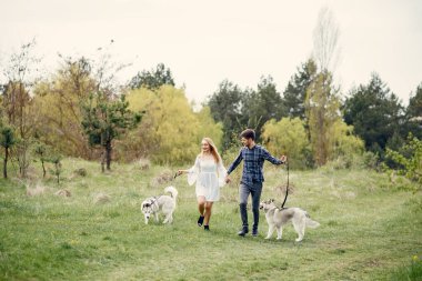 Ormandaki bir çift. Şirin köpeklerle eşleşin. Beyaz elbiseli bayan.