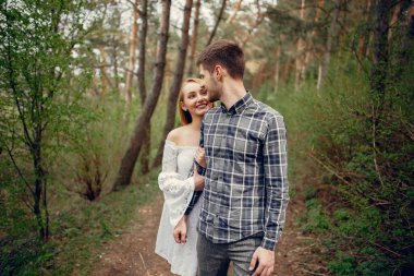 Parktaki sevimli çift. Beyaz elbiseli kadın. Mavi gömlekli adam.