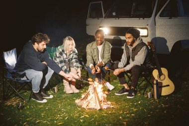Gitar çalan Müslüman bir adam, arkadaş listesi. Gençler sonbaharda piknikte eğlenirler..