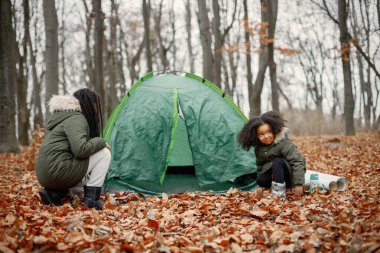 Ormanda kamp yapan güzel siyah kızlar. İki küçük kız kardeş sonbahar ormanında bir çadır kuruyorlar. Hakiki ceket giyen siyah kızlar..
