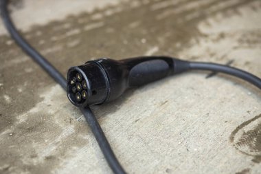 Elektrikli araba fişi ve yerde kablo var.