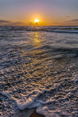 Gökyüzünde bütün gün yürüdükten sonra, büyük, ağır ve çok sıcak bir güneş topu Baltık Denizi 'nin soğuk sularında soğumak üzere..