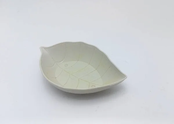 Isolated objects: small leaf-shaped plates usually used for chili sauce, on white background
