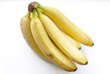 Beyaz arka planda muzlar. Beyazın üstünde muz demeti. Birlikte birkaç taze muz. Beyazın üstünde muzların sarı rengi.