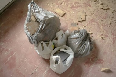 Kirli zeminde inşaat mussörü olan paketler. Paketlerde inşaat muskası. Onarım sırasında kir..