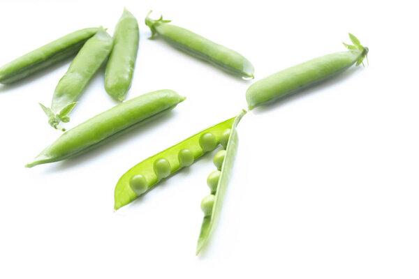 Открытая капсула с горохом внутри. Зеленый горошек в стручке на белом фоне. Зеленый горох стручки на белом фоне.