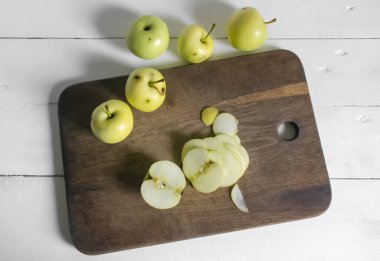 Solucan elmaları işleniyor. Siyah noktalı çürük elmalar. Ekin işleme. Tahtada elma dilimlemek..