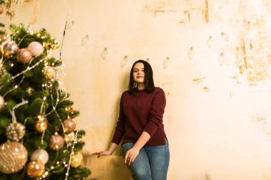 Noel ağacının yanında poz veren kadın.