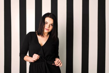 Stüdyoda beyaz çizgili bir gömleğin duvarındaki güzel bir kızın portresi.