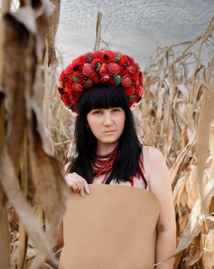 Kafasında kırmızı çelenk olan bir kızın portreleri.