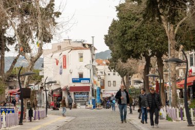 Yerel halk ve turistler, Türkiye 'nin İzmir ilinin büyüleyici bir kıyı kenti olan Foa' da bahar gününün keyfini çıkarıyorlar. Güzel plajları, tarihi limanı ve lezzetli deniz ürünleri restoranları ile ünlüdür.. 