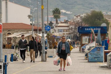 Yerel halk ve turistler, Türkiye 'nin İzmir ilinin büyüleyici bir kıyı kenti olan Foa' da bahar gününün keyfini çıkarıyorlar. Güzel plajları, tarihi limanı ve lezzetli deniz ürünleri restoranları ile ünlüdür.. 