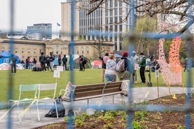 Öğrencilerin Filistin yanlısı bir kampla kampüsü işgal ettiği King College Circle 'ın kapısından Filistin hakları için küresel hareketler yansıtırken fikir ayrılıklarını dışlayan engeller koyan, kampüs polisini yoğunlaştıran