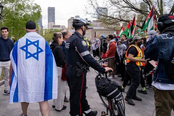 Kanada, Toronto - 8 Mayıs 2024: Filistin yanlısı ve İsrail yanlısı protestocular, Toronto Üniversitesi 'ndeki King' s College Circle 'ı işgal eden öğrenci kampı önünde yoğun bir değişim ile görüşlerini tutkuyla ifade ettiler.