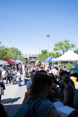 TORONONTO, ONTARIO, CANADA - 26 Mayıs 2024: İnsanlar güzel bir bahar gününde bir gıda pazarına giderler