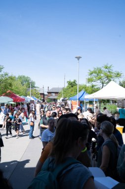 TORONONTO, ONTARIO, CANADA - 26 Mayıs 2024: İnsanlar güzel bir bahar gününde bir gıda pazarına giderler