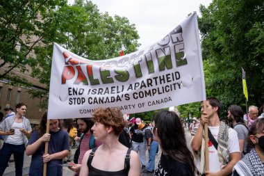 Toronto Üniversitesi kampüsündeki King 's College Circle' da düzenlenen mitingde insanlar Filistin 'i desteklemek için tabelalar asıyor.. 