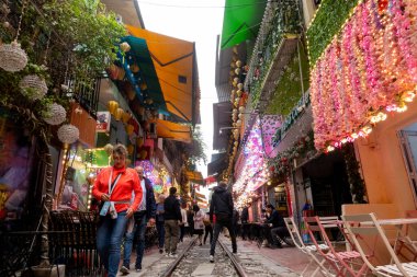 Turistler ve yerliler trenin Hanoi, Vietnam 'daki tren sokağına varmasını bekliyorlar.. 