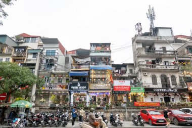 HANOI, VİETNAM - 10 Mart 2025: Arka planda binalar ve ön planda insanlarla birlikte Vietnam Treni Caddesi 'nin sokak manzarası.