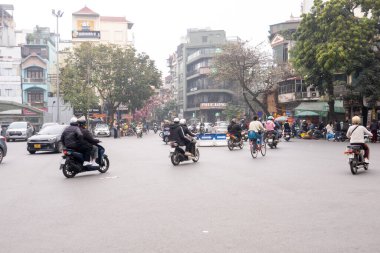 HANOI, VİETNAM - 10 Mart 2025: İnsanlar Hanoi, Vietnam 'da Fransız Mahallesi yakınlarında motosikletlerine biniyorlar.