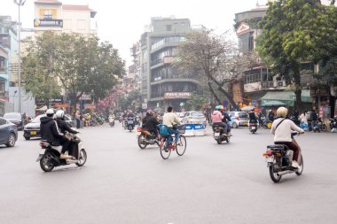 HANOI, VİETNAM - 10 Mart 2025: İnsanlar Hanoi, Vietnam 'da Fransız Mahallesi yakınlarında motosikletlerine biniyorlar.