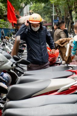 HANOI, VİETNAM - 10 Mart 2025: Sürücü Hanoi, Vietnam 'da motosikletine binmeye hazırlanıyor.