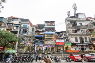 HANOI, VİETNAM - 10 Mart 2025: Arka planda binalar ve ön planda insanlarla birlikte Vietnam Treni Caddesi 'nin sokak manzarası.