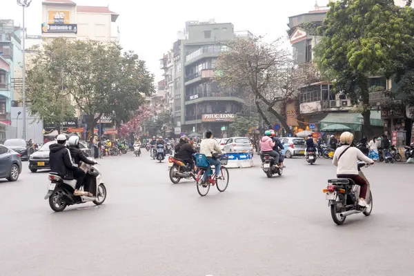 HANOI, VİETNAM - 10 Mart 2025: İnsanlar Hanoi, Vietnam 'da Fransız Mahallesi yakınlarında motosikletlerine biniyorlar.