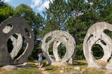 Turist, Burk Şelaleleri 'nin Çığlık Atan Kafaları olarak bilinen Kanadalı sanatçı Peter Camani' nin taştan heykellerinin fotoğrafını çekiyor..