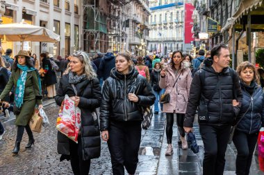 Napoli, İtalya - 10 Aralık 2022: Şehrin tarihi merkezinde kalabalık bir cadde. İnsanlar kasvetli bir günde sokakta yürürler..