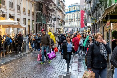 Napoli, İtalya - 10 Aralık 2022: Şehrin tarihi merkezinde kalabalık bir cadde. İnsanlar kasvetli bir günde sokakta yürürler..