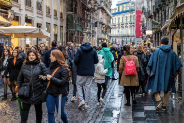 Napoli, İtalya - 10 Aralık 2022: Şehrin tarihi merkezinde kalabalık bir cadde. İnsanlar kasvetli bir günde sokakta yürürler..