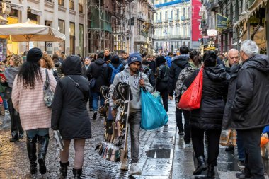 Napoli, İtalya - 10 Aralık 2022: Şehrin tarihi merkezinde kalabalık bir cadde. İnsanlar kasvetli bir günde sokakta yürürler..