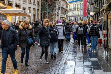Napoli, İtalya - 10 Aralık 2022: Şehrin tarihi merkezinde kalabalık bir cadde. İnsanlar kasvetli bir günde sokakta yürürler..