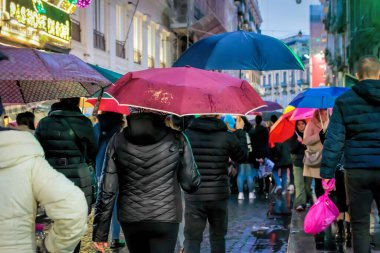 Napoli, İtalya - 10 Aralık 2022: Şehrin tarihi merkezinde kalabalık bir cadde. İnsanlar kasvetli bir günde sokakta yürürler..