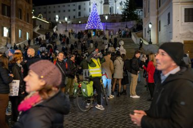 Roma, İtalya - 26 Kasım 2022 Bisikletçi Noel ışıklarıyla süslenmiş kalabalık İspanyol Merdivenlerinde cep telefonuyla selfie çekiyor.