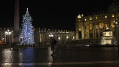 Rome, Italy - December 31, 2022: St. Peter's square decorated with the Christmas tree illuminated. The facade of the basilica filmed at night, slow motion footage.